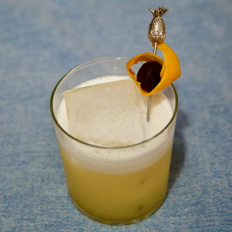 Un Amaretto Sour garni d'une cerise confite et d'un orange peel
