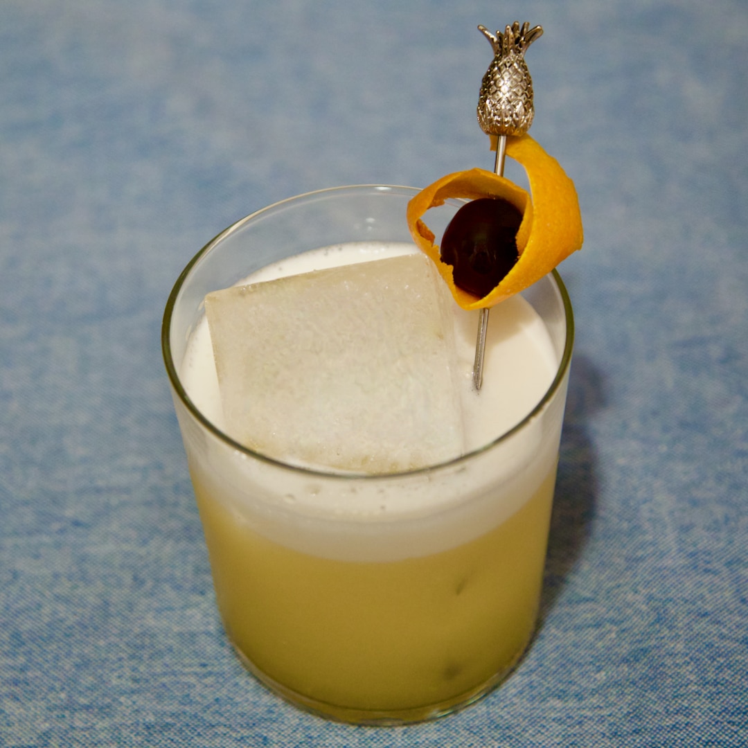Un Amaretto Sour garni d'une cerise confite et d'un orange peel