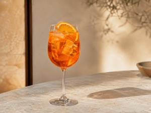 Aperol Spritz en un vaso de vino con hielo y rodaja de naranja